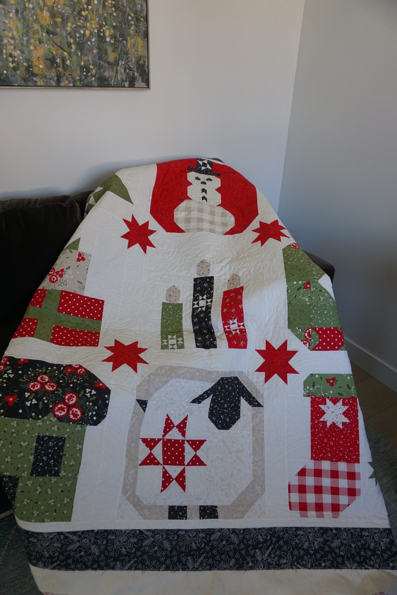Christmas sampler quilt draped over a couch showing Holly Berry Holiday longarm quilting texture